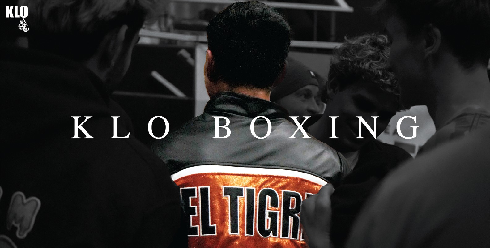 KLO, back turned, surrounded by his corner before a session.
